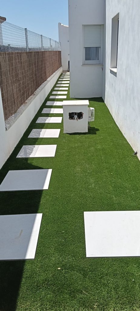 Césped artificial instalado en pasillo lateral de vivienda - Limcesped Sevilla